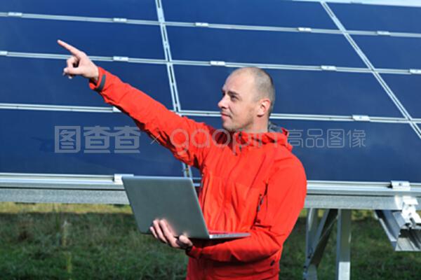 在太陽能電池板工廠使用筆記本電腦的工程師